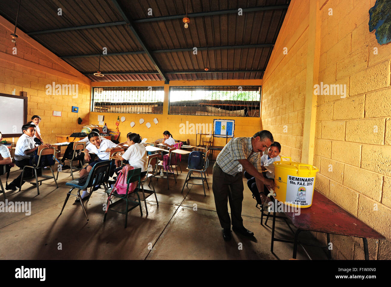 Guatemala, Retalhuleu, Lehrer (Jorge Leionel Hernandez Cardona 49) dienen und Trinkwasser im Klassenzimmer Stockfoto