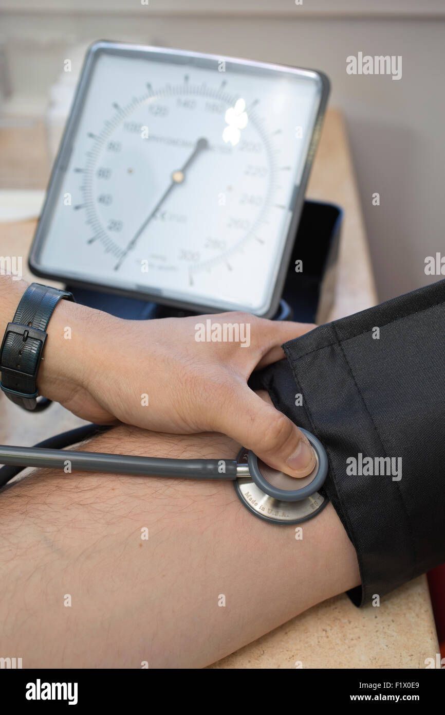 Bauarbeiter mit dem Blutdruck Test und allgemeine Gesundheit überprüfen vor Ort, England, UK Stockfoto