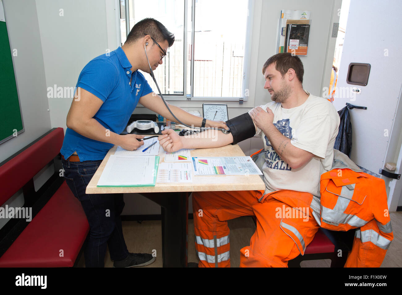Bauarbeiter unter Blutdruck Test und der allgemeine Gesundheitszustand überprüfen vor Ort, England, UK Stockfoto