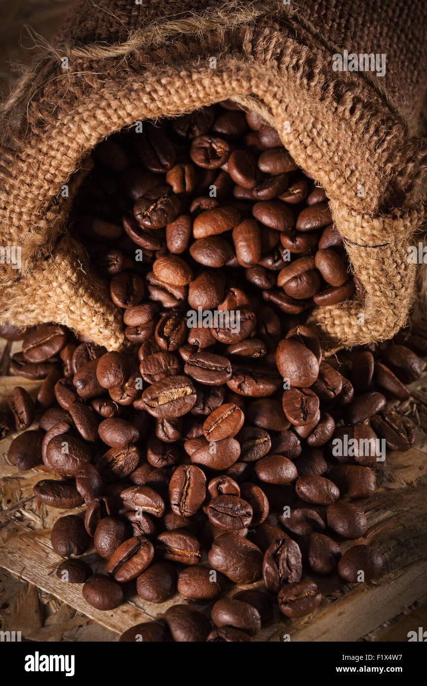 Tasche mit Kaffeebohnen isoliert auf dem hölzernen Hintergrund. Stockfoto