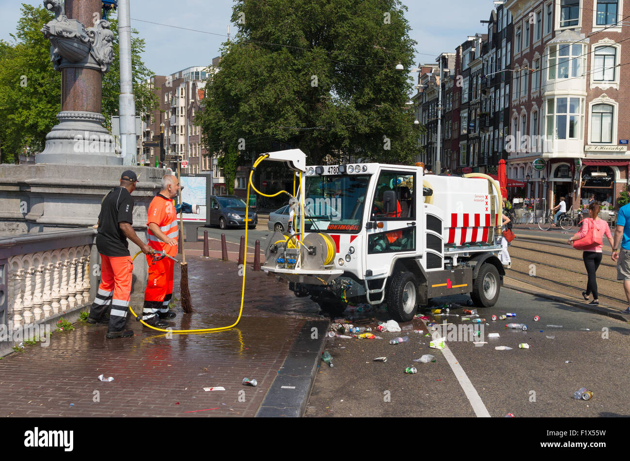 AMSTERDAM - 2. August 2015: Unbekannt Arbeiter von der Stadtreinigung Abteilung Schlauch die Straßen nach der Canal Parade des Ams Stockfoto