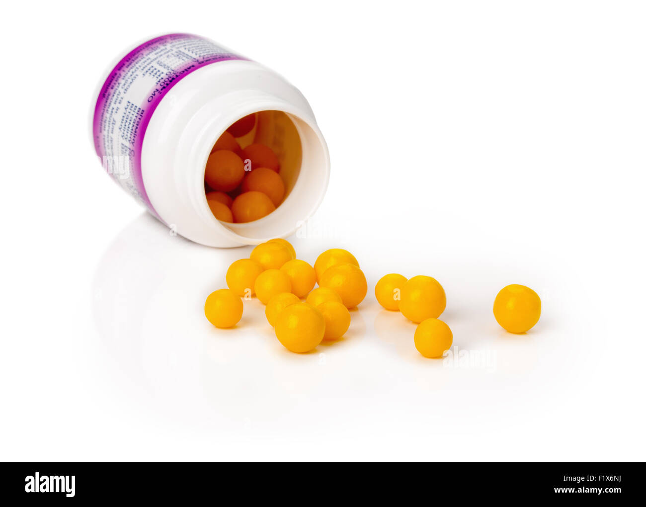 gelbe Vitamin-Pillen auf dem weißen Hintergrund. Stockfoto