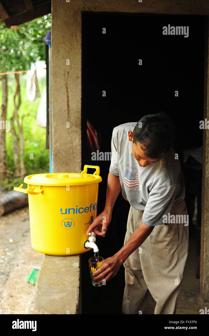 Guatemala, Salama, Vater, Zubereitung und das Servieren von Wasser mit Chlor zu trinken (Modesto Lucas Enriquez 44 Jahre) Stockfoto
