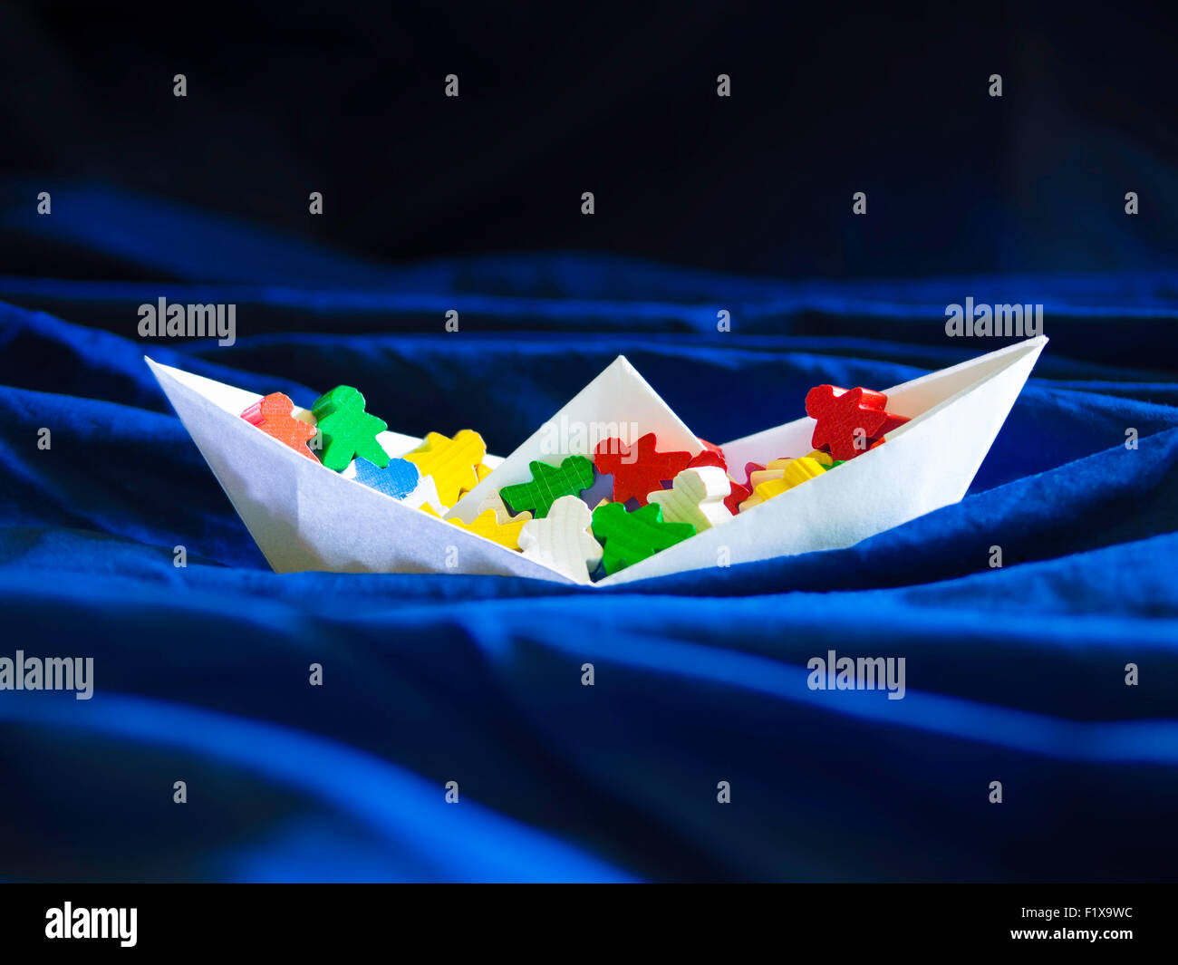 Einwanderung Auswanderung Migrationskonzept, Paperboat mit meeples Stockfoto