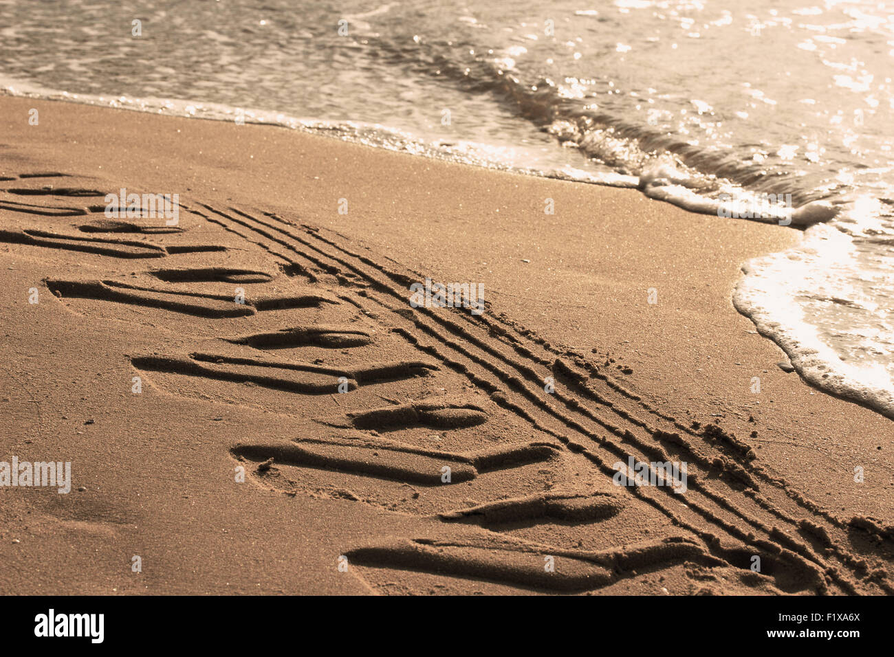 Reifenspuren auf dem Sand in der Nähe von Meer. Stockfoto