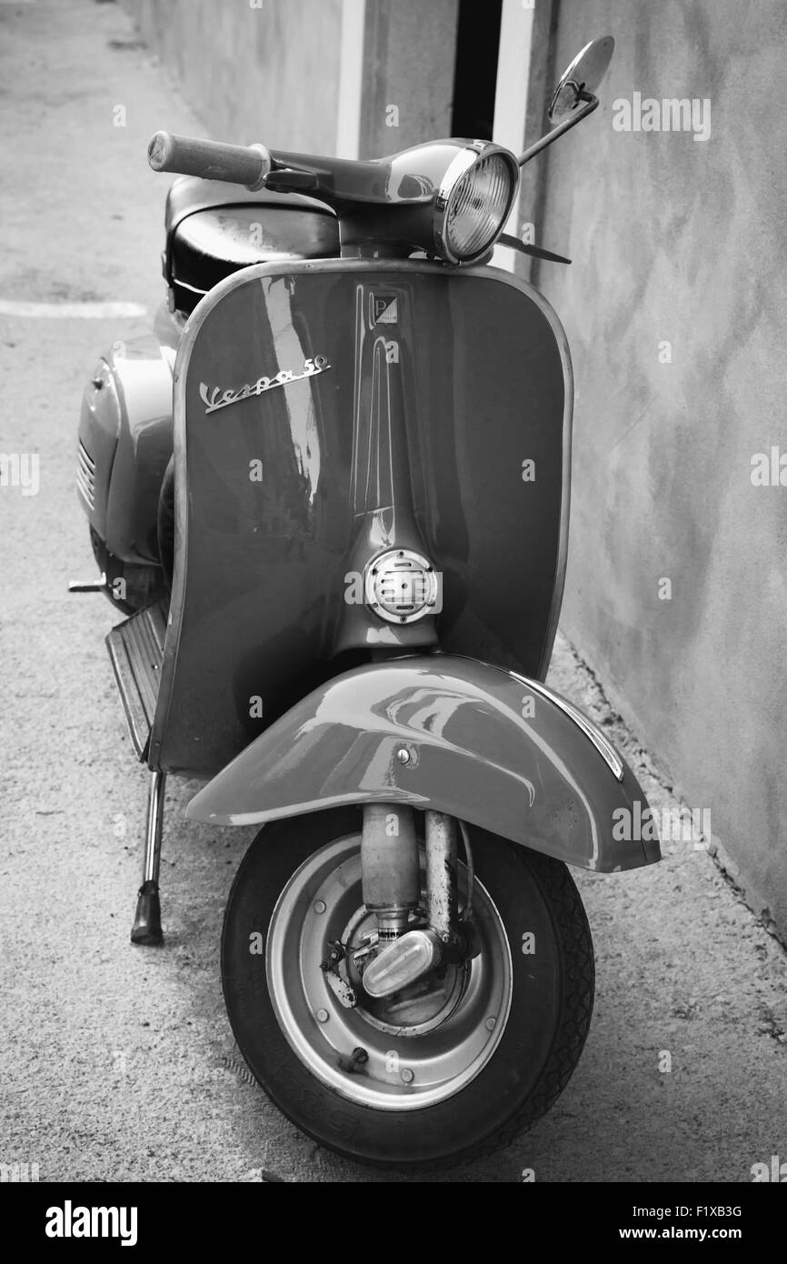 Gaeta, Italien - 19. August 2015: Klassische Vespa-Roller steht geparkt in der Nähe der Wand, vertikale Foto Stockfoto
