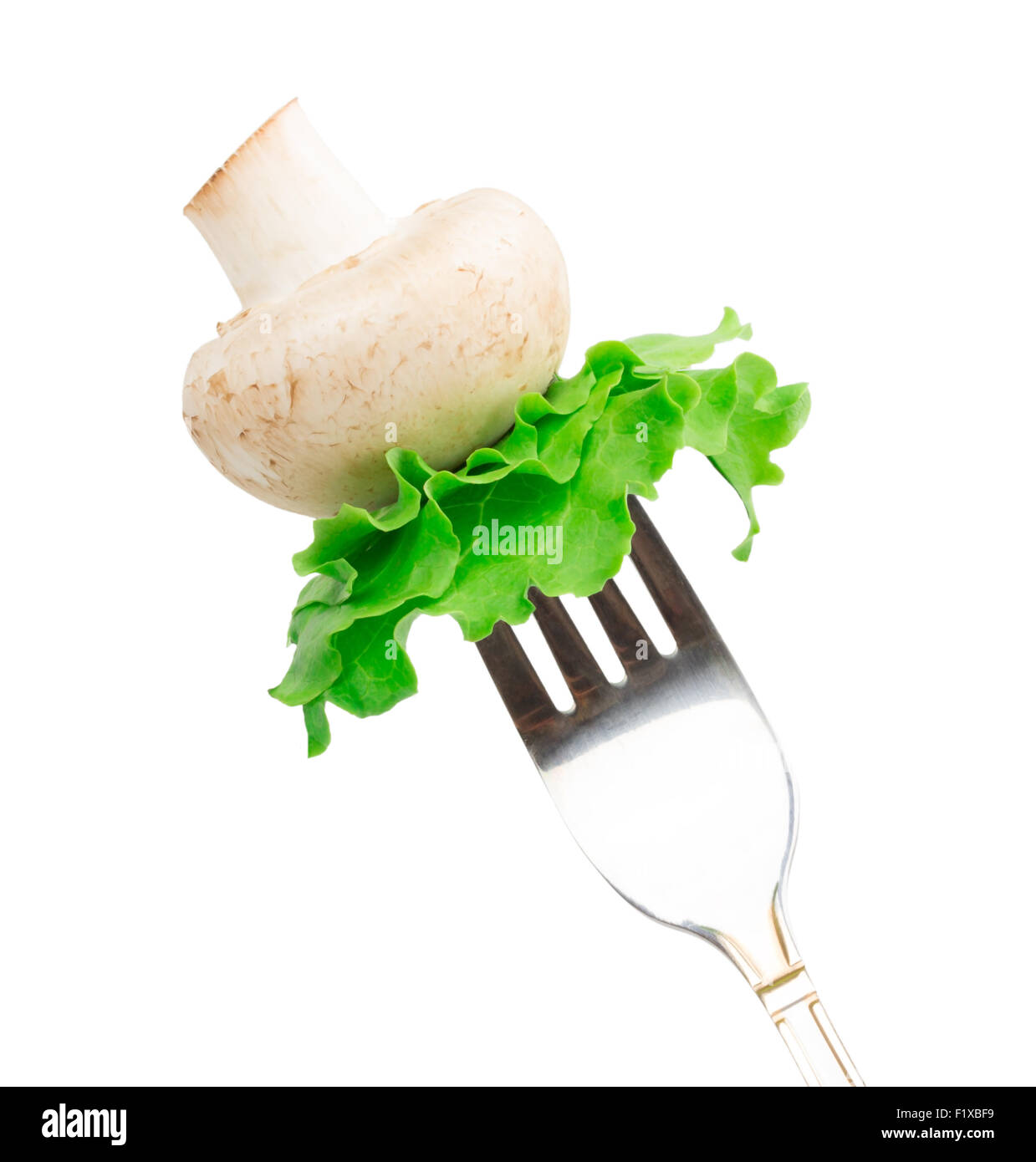Pilze und Blätter von grünem Salat auf einer Gabel isoliert auf weißem Hintergrund. Stockfoto