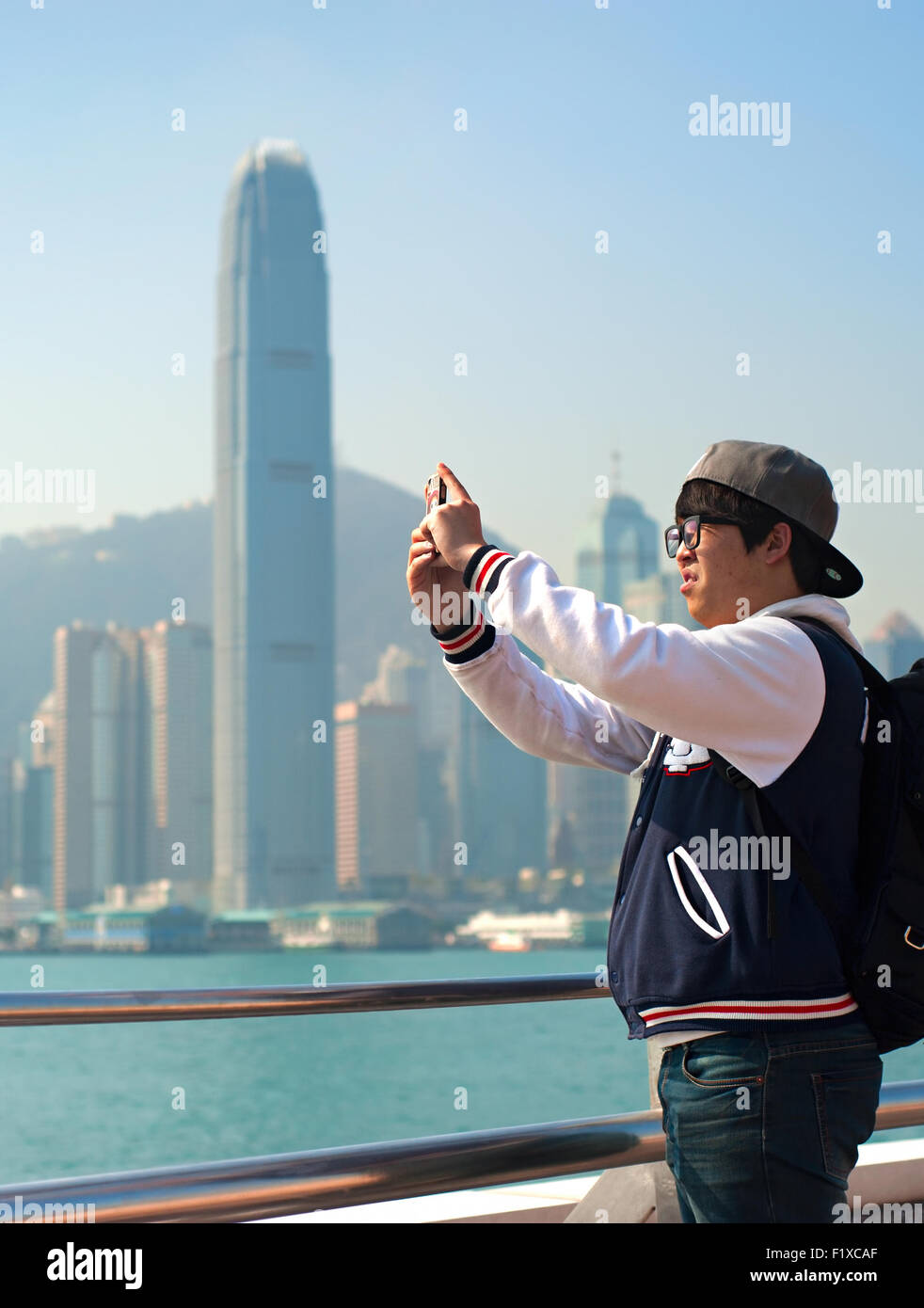 Unbekannter Mann Fotografieren Skyline von Hong Kong von seinem Handy. Stockfoto