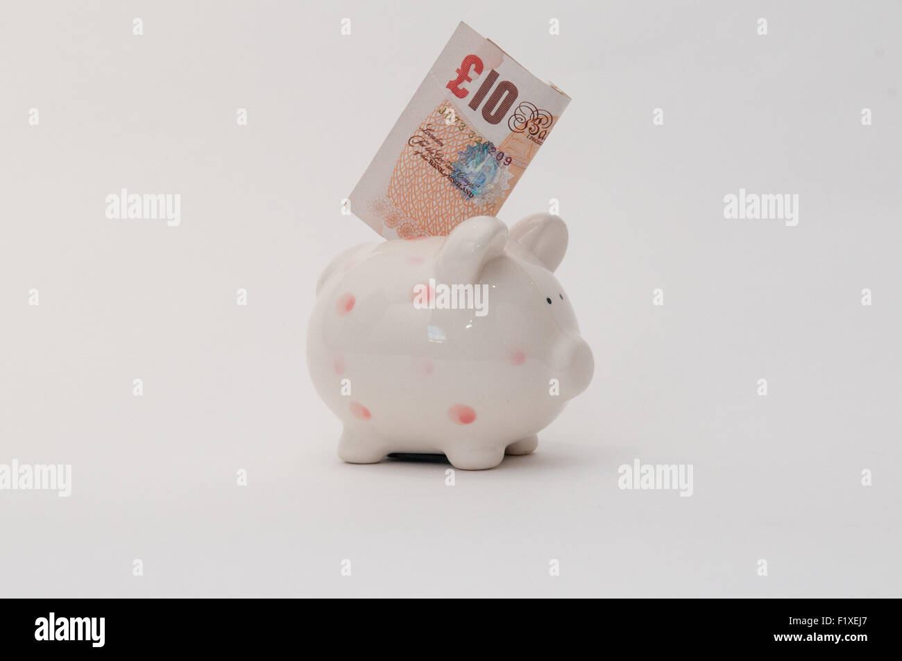 Geld in ein Sparschwein für Einsparungen Stockfoto