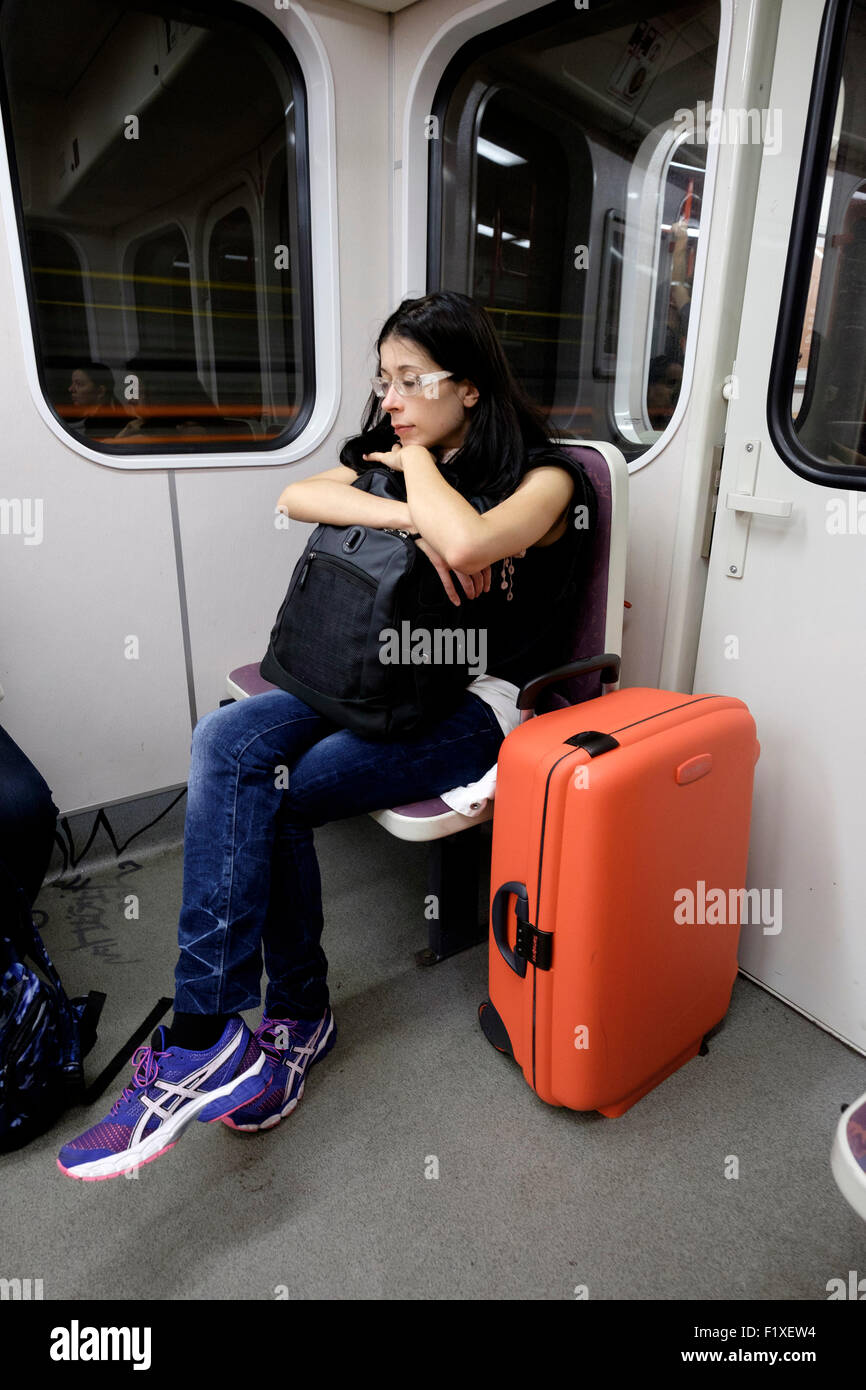 Junge Frau mit einem roten Koffer schlafen in einer u-Bahn in Prag, Tschechische Republik, Europa Stockfoto