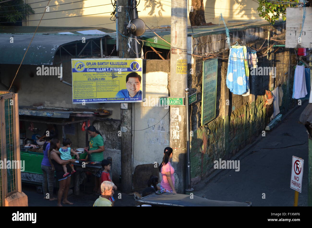M.Dela Cruz, Manila. Eine Straße Ecke wo Kundenansturm, Geschmack Thesausages als Warmedup für Saum. Abovethemthelocalpolitician Stockfoto