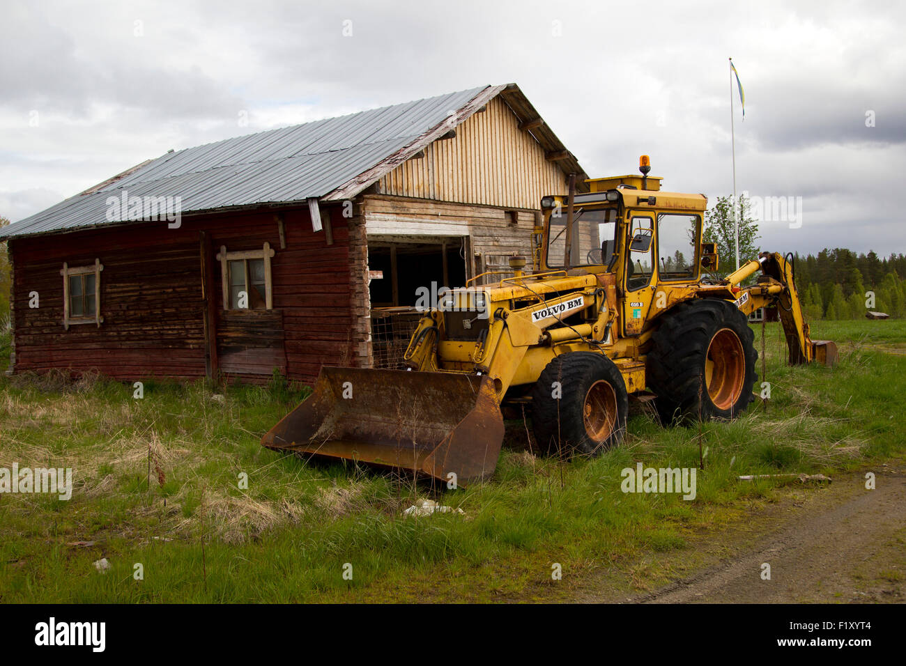 Altes Haus mit alten Traktor draußen auf dem Hof Stockfoto