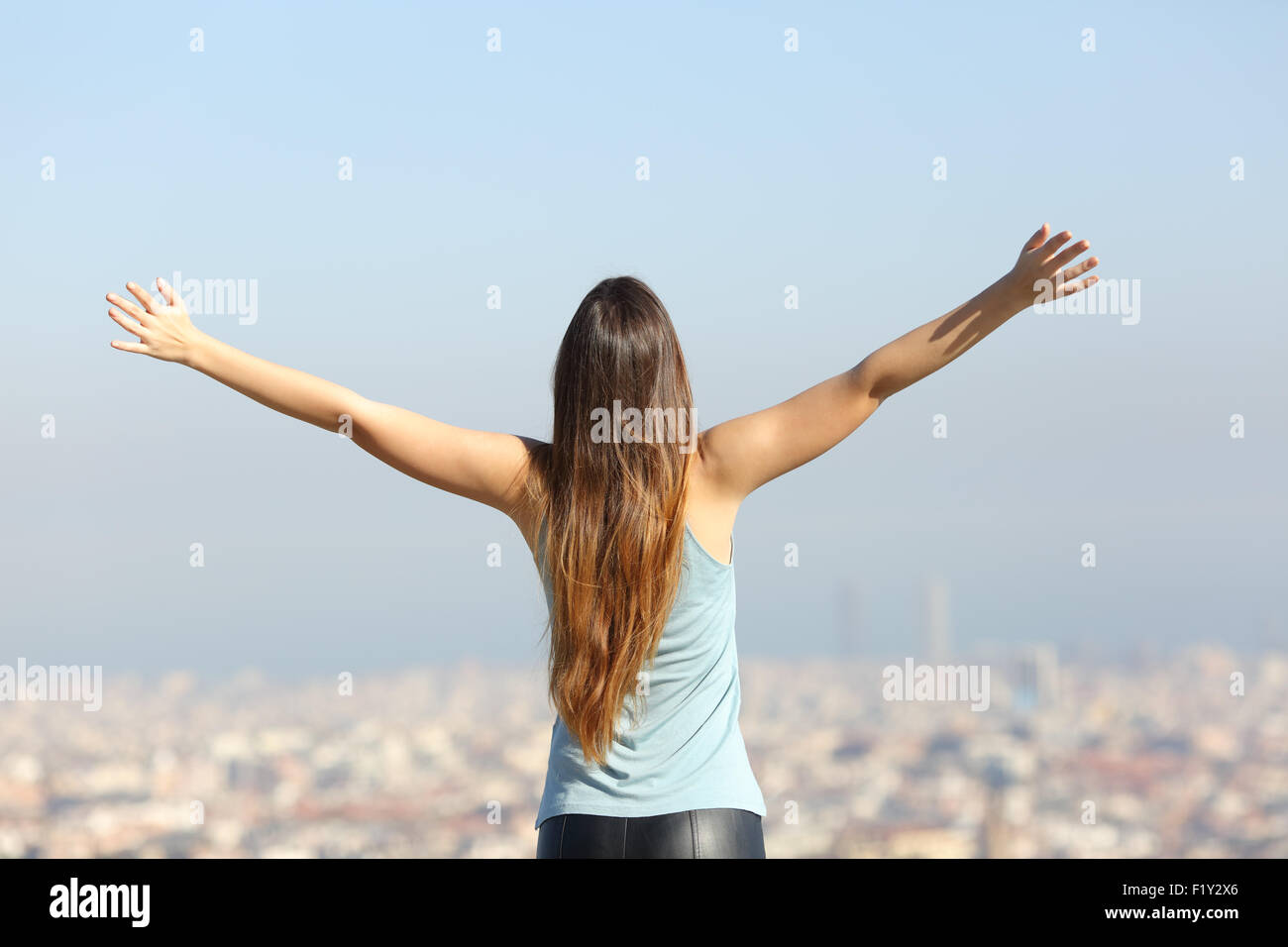 Rückansicht einer happy Tourist Frau Arme Blick auf die Stadtlandschaft Stockfoto