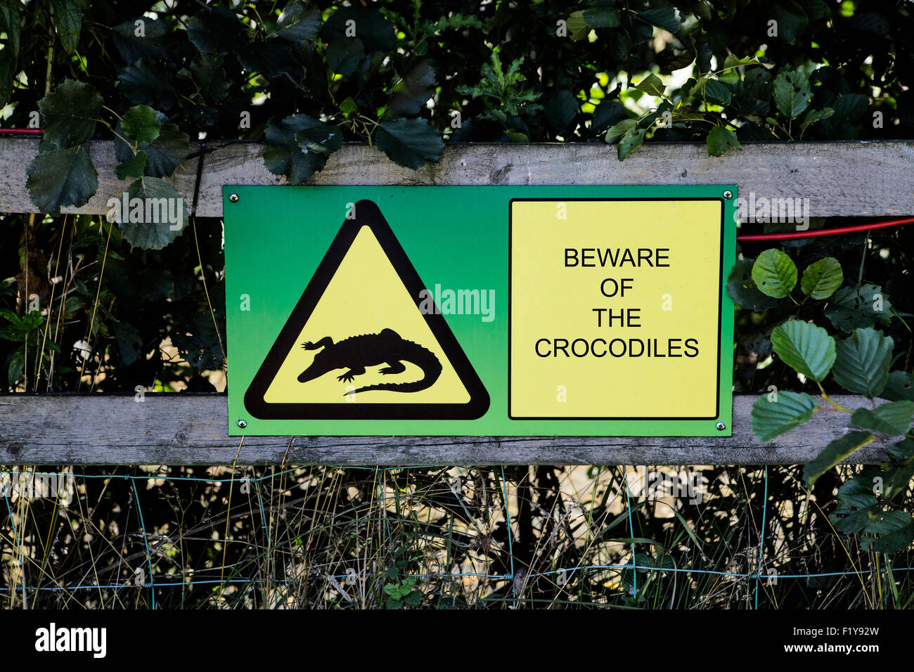 Zeichen mit einem Holzzaun Warnung Menschen verbunden zu den Krokodilen in acht nehmen Stockfoto