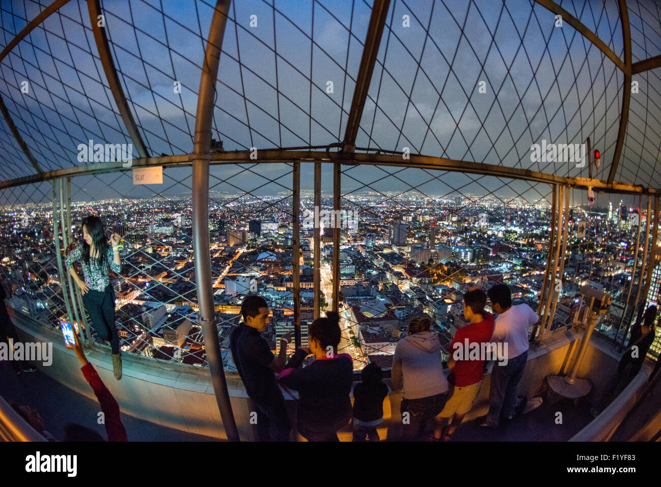Torre Latinoamericana Observatory Mexico City // MEXICO CITY, Mexiko – Touristen bewundern den Panoramablick auf Mexiko City vom Observatorium im 44. Stock des Torre Latinoamericana Gebäudes aus. Der Torre Latinoamericana, 1956 fertiggestellt, war der erste große Wolkenkratzer von Mexiko City und bleibt eines der bekanntesten Wahrzeichen der Hauptstadt. Das 181 Meter (594 Fuß) hohe Gebäude wurde von dem Architekten Augusto H. Álvarez entworfen und diente mehrere Jahre lang als das höchste Gebäude Lateinamerikas. Die Aussichtsplattform des Turms bietet einen atemberaubenden Blick über die weitläufige Metropole Stockfoto