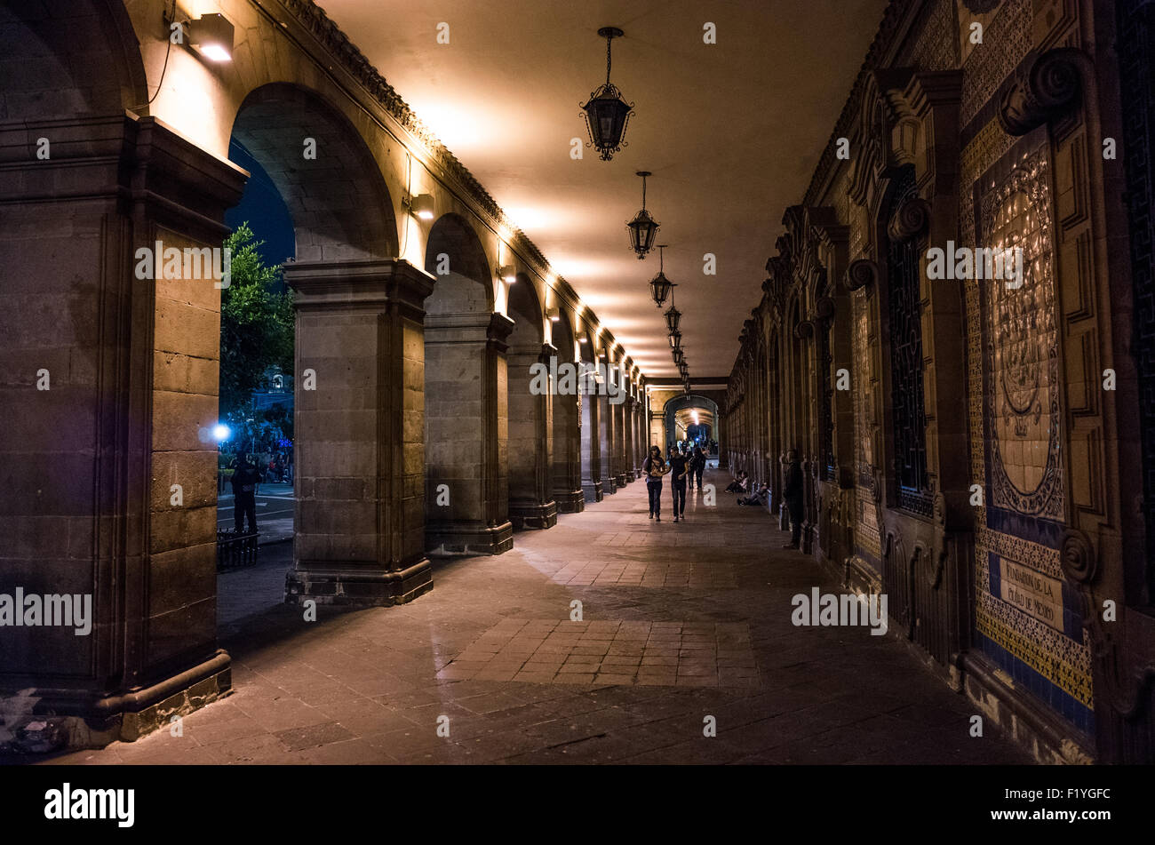 Zócalo Plaza Walkway Mexico City // MEXIKO-STADT, Mexiko – Ein Fußweg führt entlang eines der Gebäude, die den Zócalo, den Hauptplatz von Mexiko-Stadt, umgeben. Die Zócalo, die früher als Plaza de la Constitución bekannt ist, ist der zentrale platz und das zeremonielle Zentrum von Mexiko-Stadt und geht ihren Ursprung bis zum aztekischen Zeremonialzentrum Tenochtitlan zurück. Der Platz ist von wichtigen Regierungsgebäuden und der Metropolitan Cathedral umgeben, die als politisches und religiöses Herz der Stadt dient. Mit etwa 57.600 Quadratmetern (240 Meter x 240 Meter oder 787 Fuß x 787 Fuß) zählt sie zu den größten Städten Stockfoto