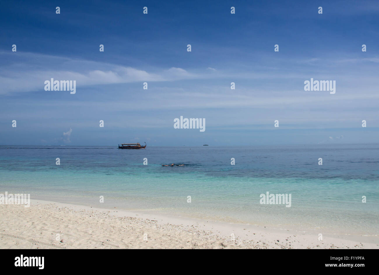 Strand, Meer, bewölktem Himmel und schwimmende Boot Stockfoto