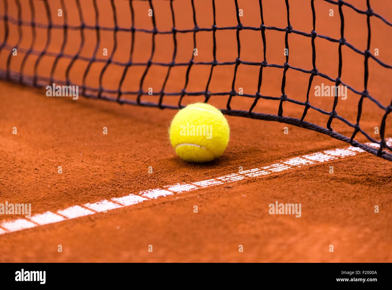 gelben Tennisball auf einem roten Sandplatz Stockfoto