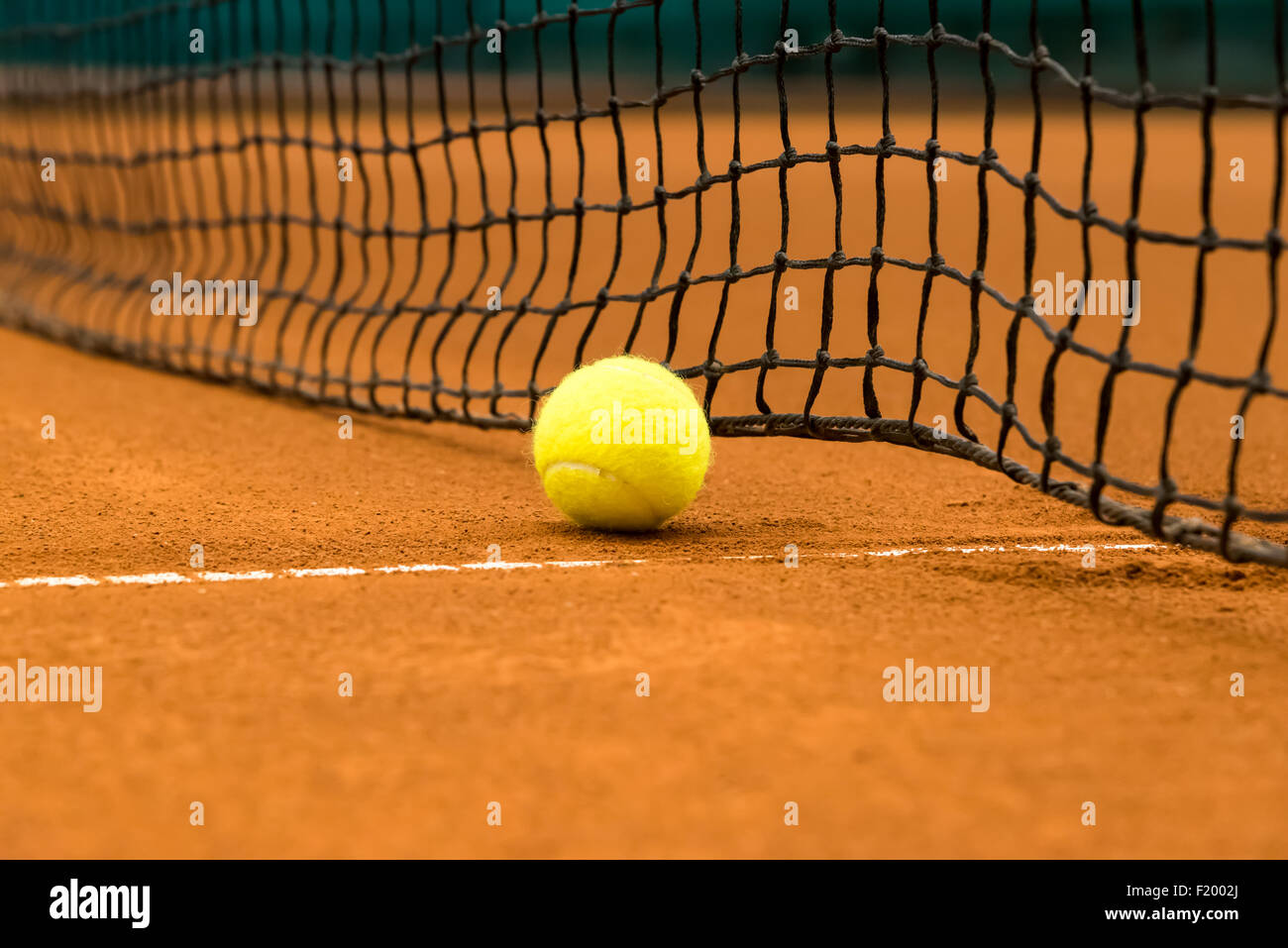 gelben Tennisball auf einem roten Sandplatz Stockfoto