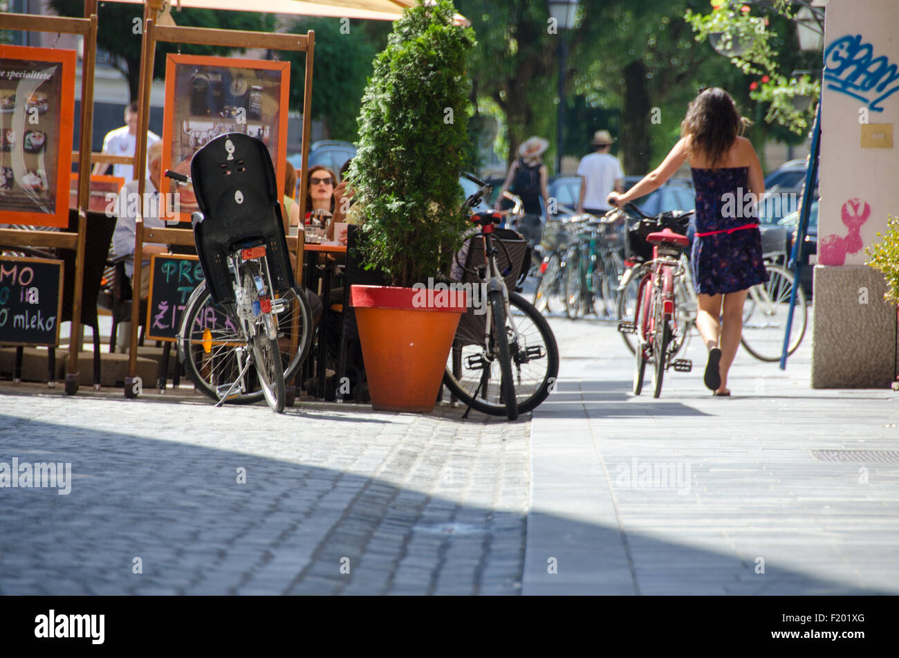 Ein junges Mädchen mit ihrem Fahrrad, zu Fuß in Ljubljana. Stockfoto