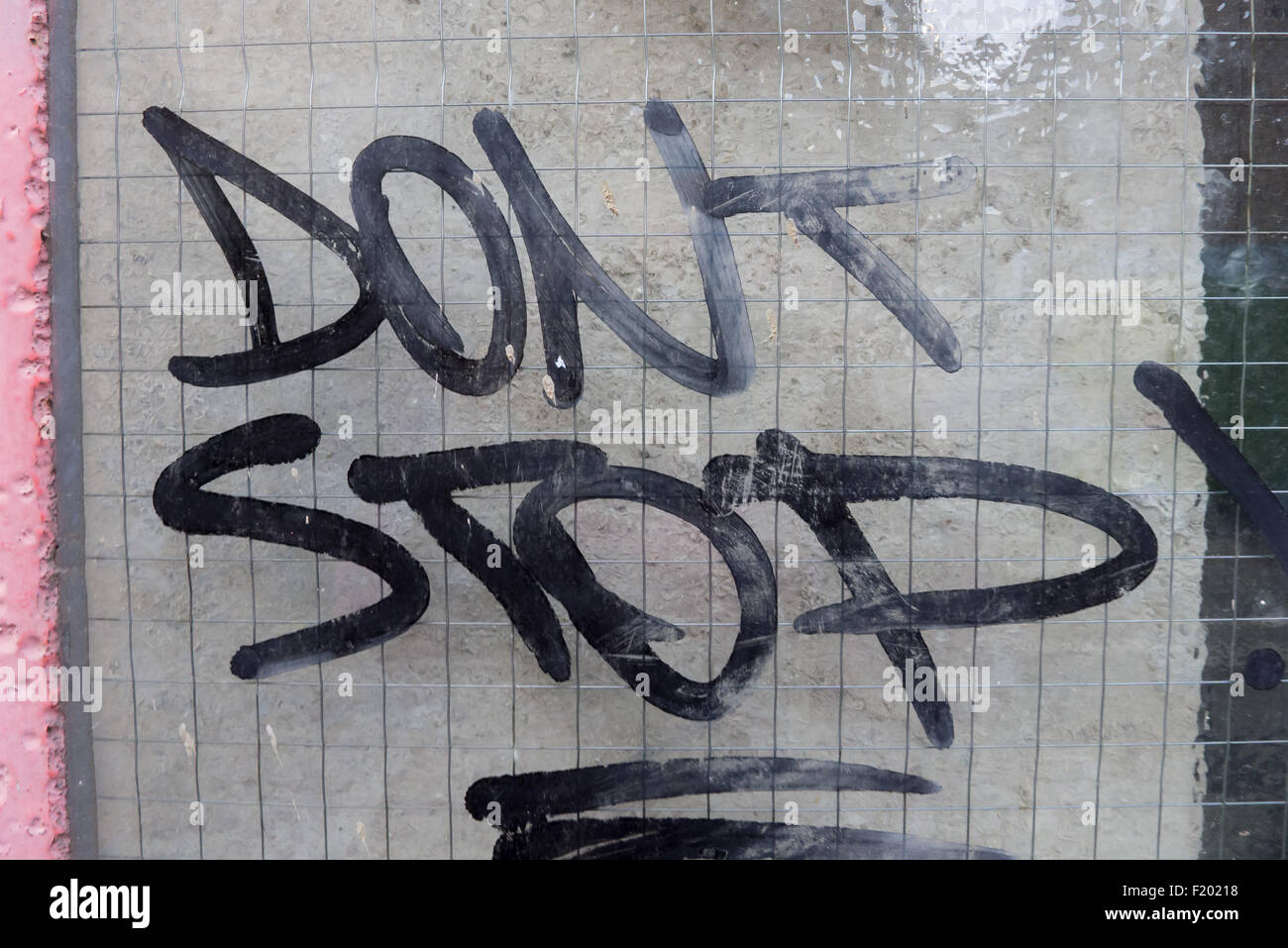 Spitalfields, London. Graffiti auf einer georgischen Drahtglas-Scheibe "Dont Stop". Stockfoto