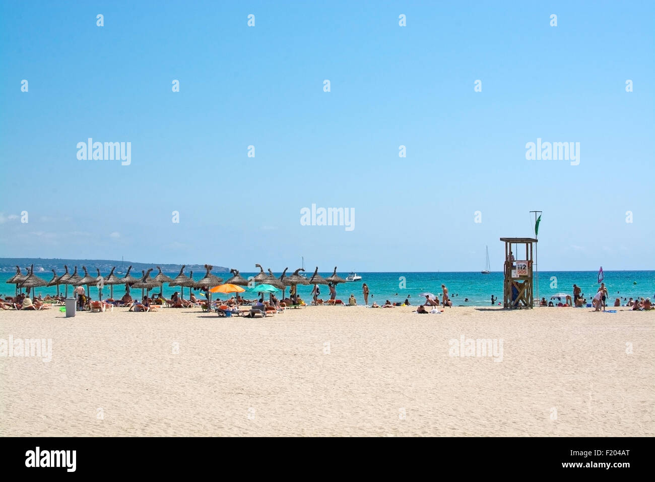 Strand mit Sonnenschirmen und Rettungsschwimmer an einem sonnigen Sommertag am 27. Juli 2015 in Mallorca, Balearen, Spanien. Stockfoto