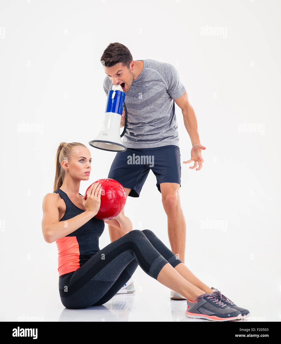 Konzept-Foto eines Trainers schreien über Lautsprecher auf eine Frau, die Übungen auf einem weißen Hintergrund isoliert Stockfoto