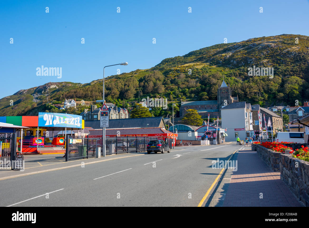 Kirmes und Road to High Street über Bahnübergang in Barmouth Gwynedd Wales UK Stockfoto