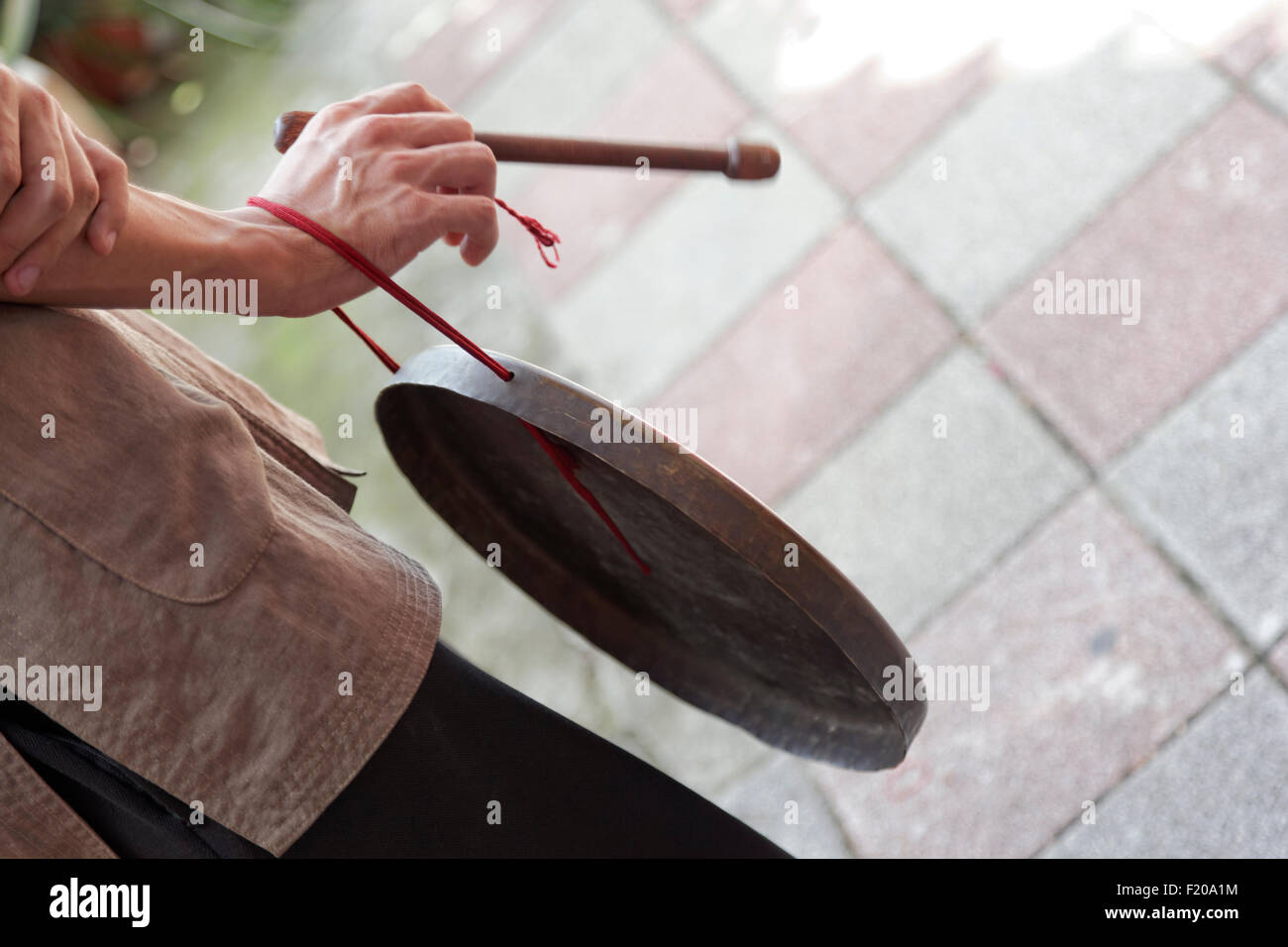 ein mans Hand schlagen eine Blechtrommel im Rahmen einer Zeremonie Stockfoto