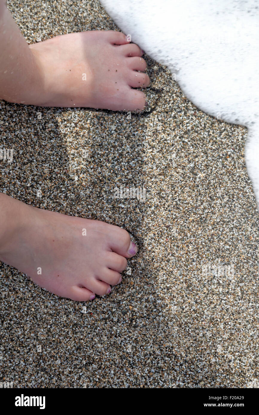 Kinder spielen im Wasser mit den Wellen am Strand Stockfoto