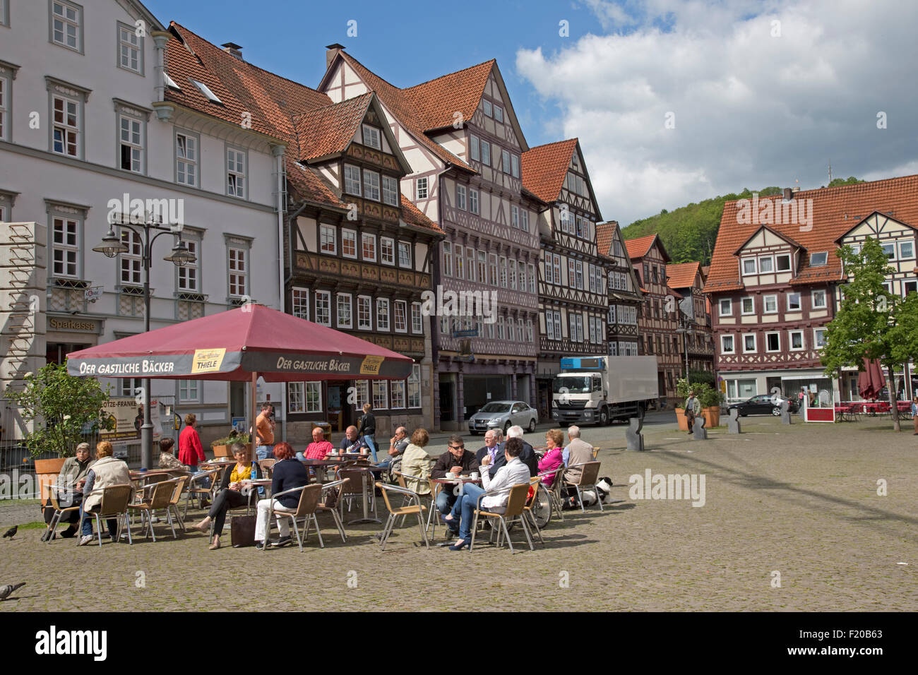 Menschen sitzen vor Café in Stadt quadratisch Fachwerkhäusern Hann Munden Deutschland Stockfoto