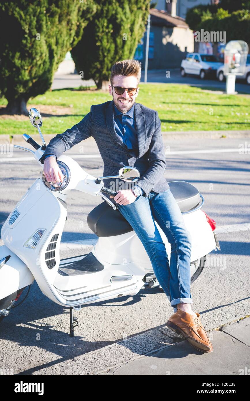 Porträt von stilvollen Jüngling auf moped Stockfoto