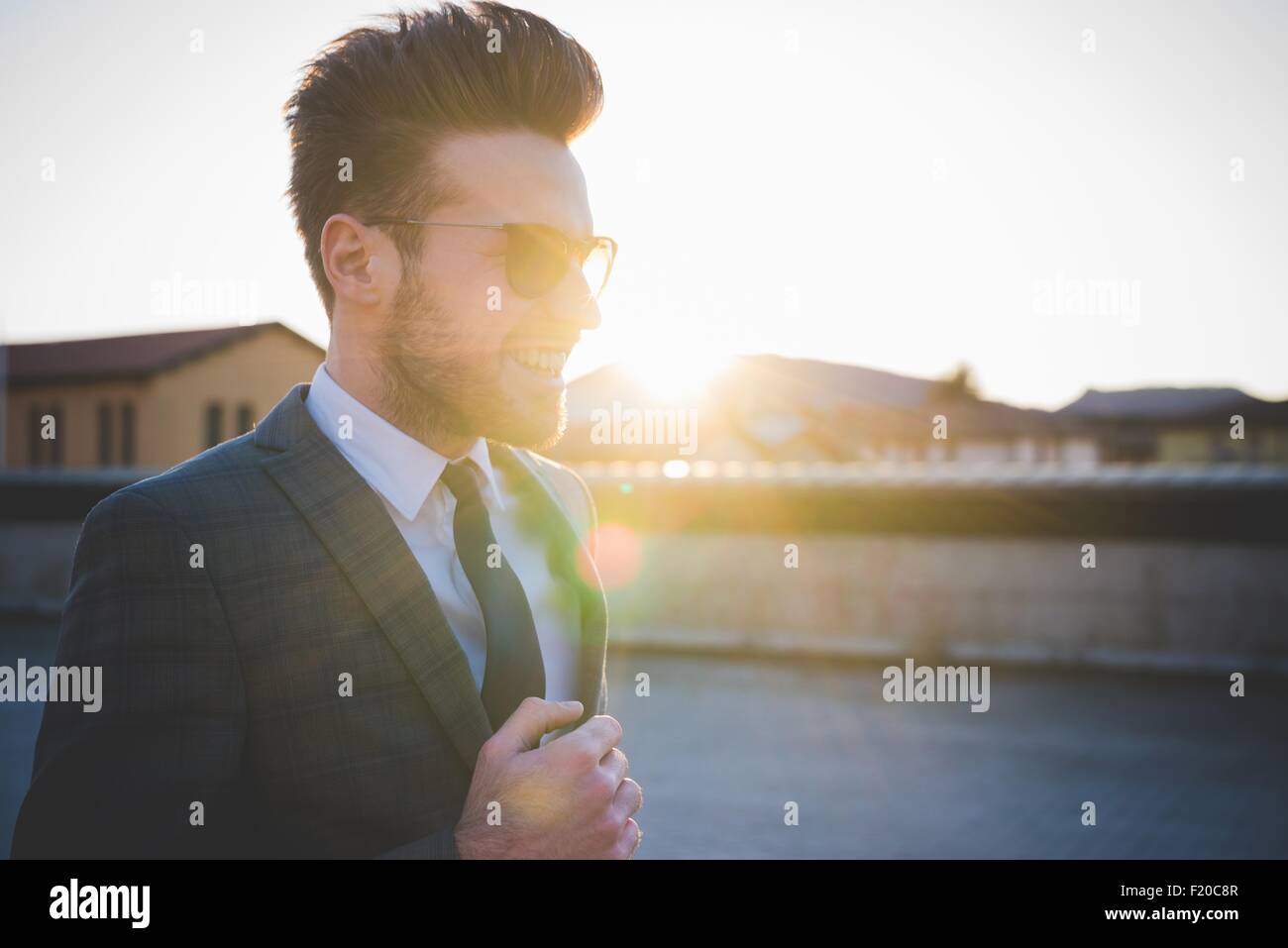 Stilvolle junge Mann trägt Farbtöne im Sonnenlicht Stockfoto