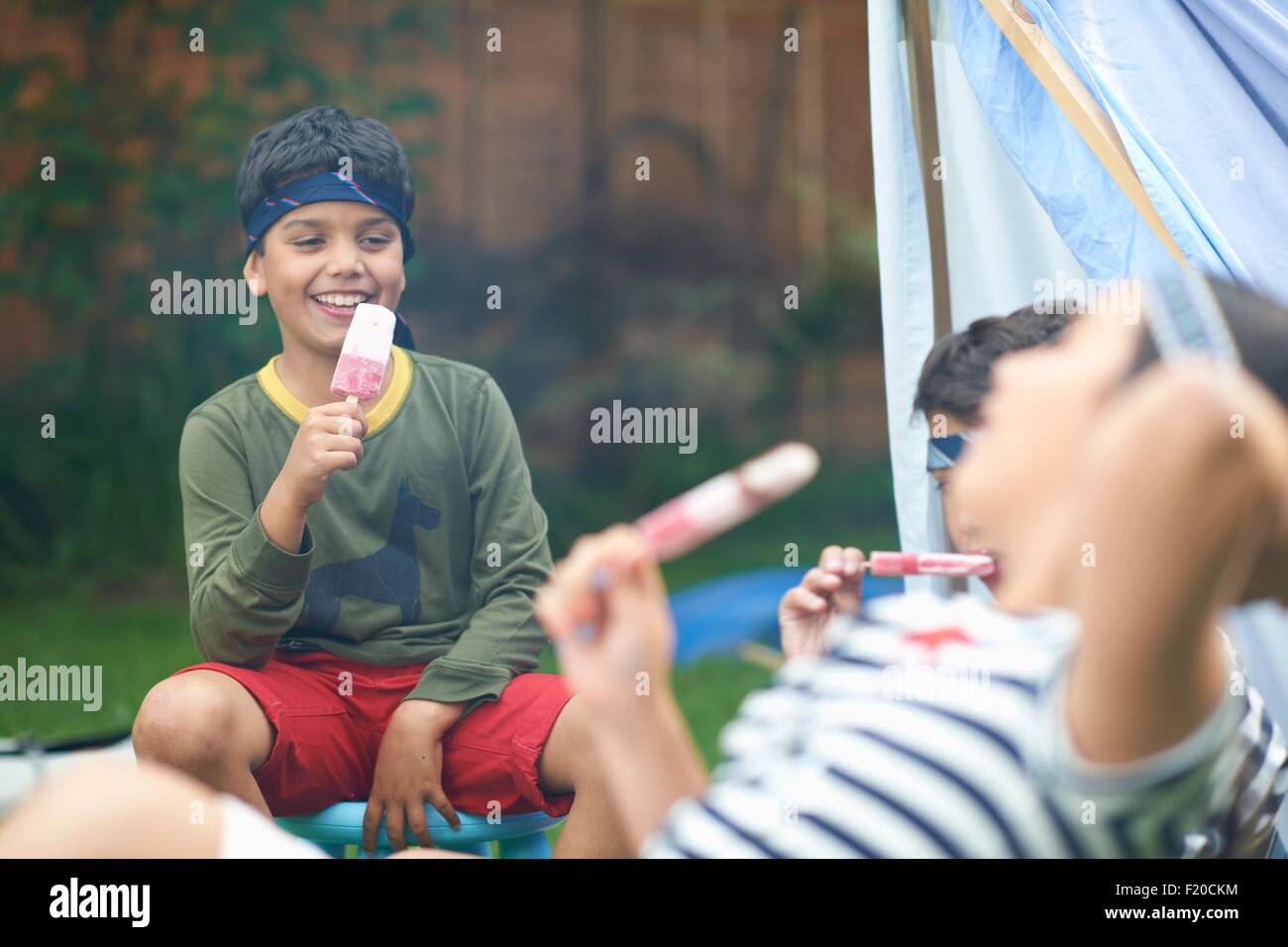Mädchen und zwei Brüder, essen Eis am Stiehl im Garten Stockfoto Mädchen und zwei Brüder, essen Eis am Stiehl im Garten Stockfoto