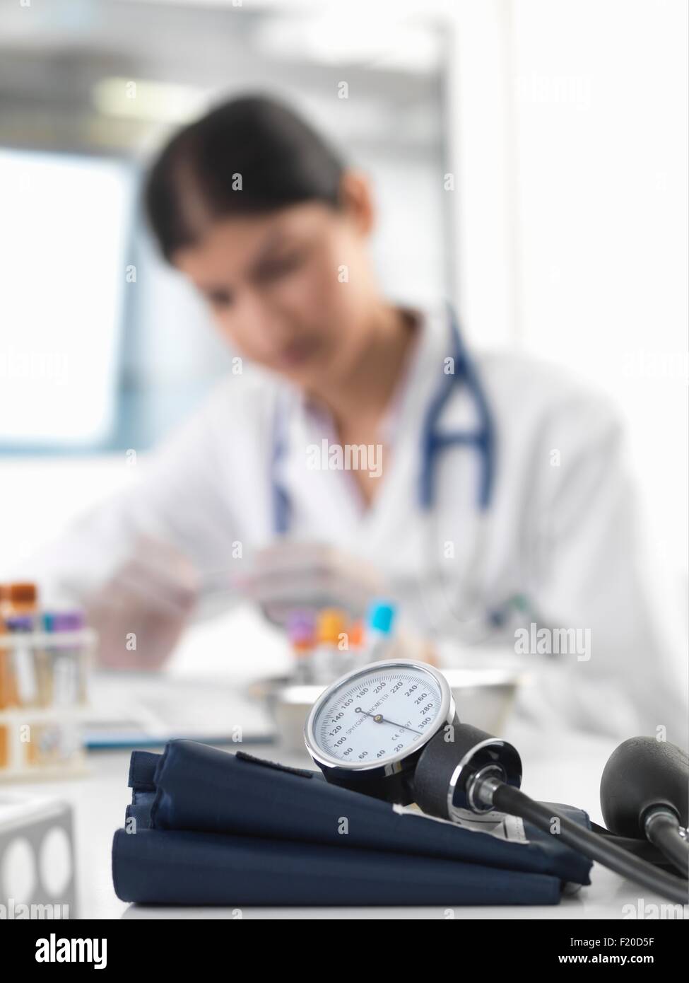 Ärztin untersucht Reagenzglas am Schalter in Klinik Stockfoto