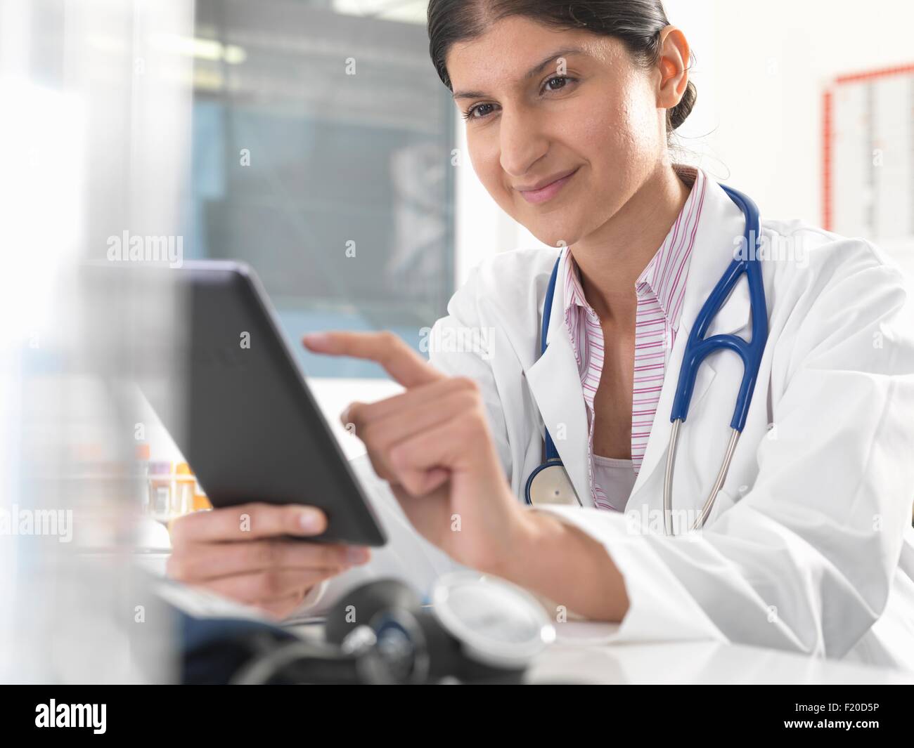 Ärztin mit digital-Tablette Touchscreen Patientenakten aktualisieren Stockfoto