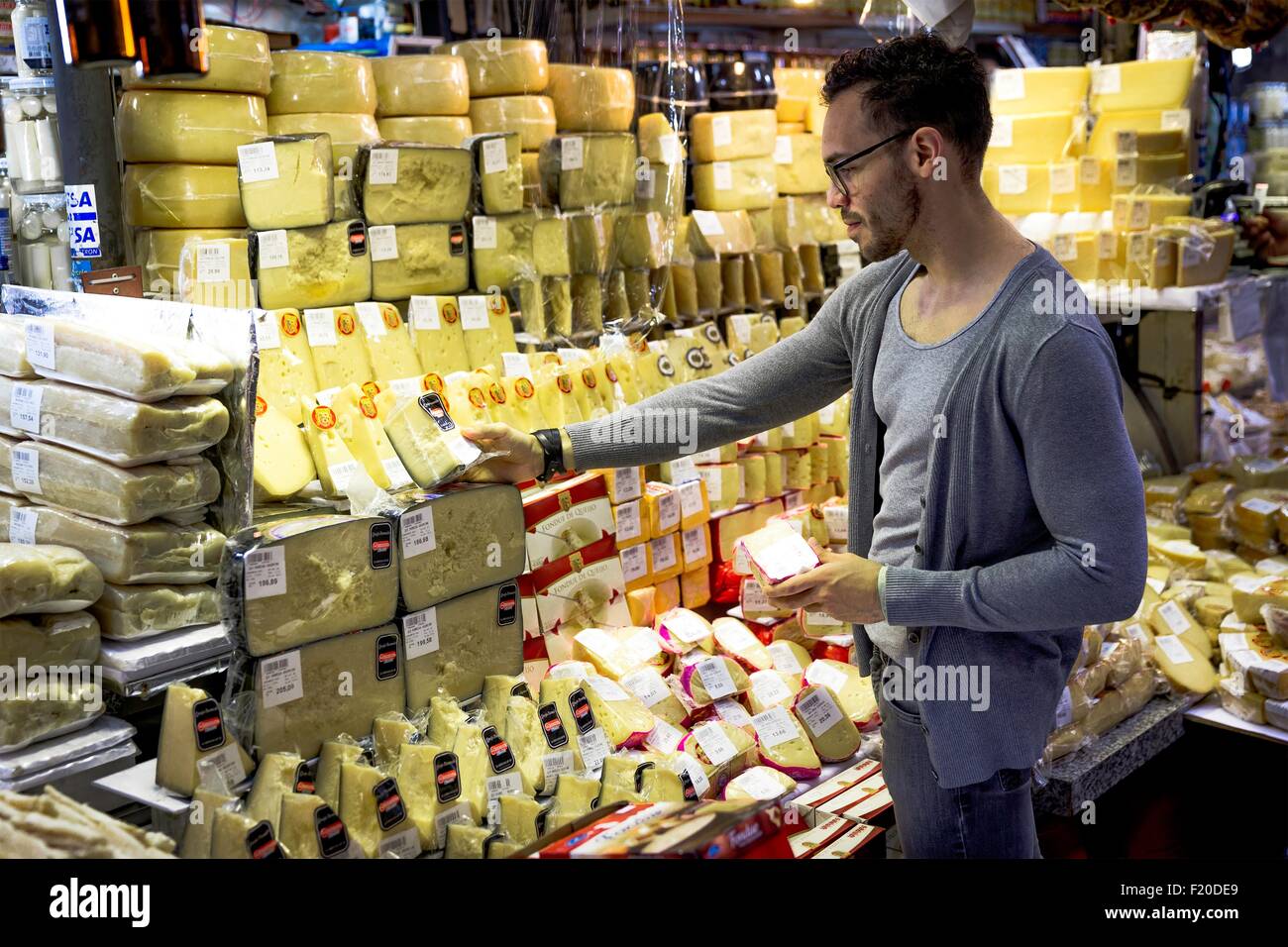 Junger Mann, die Auswahl von Käse in Feinkost Marktstand, Sao Paulo, Brasilien Stockfoto