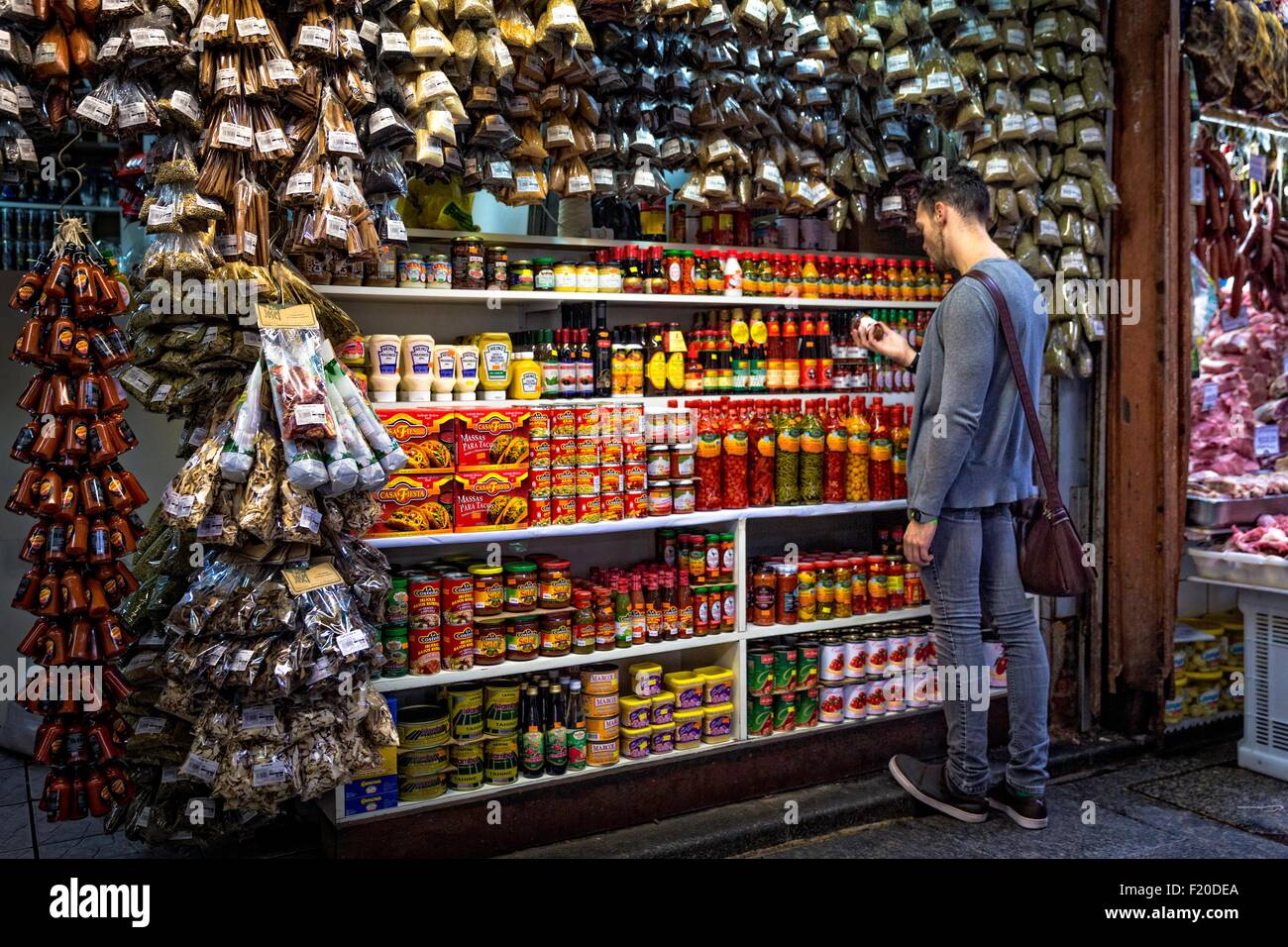Junger Mann, die Auswahl der Gewürze in Marktstand, Sao Paulo, Brasilien Stockfoto