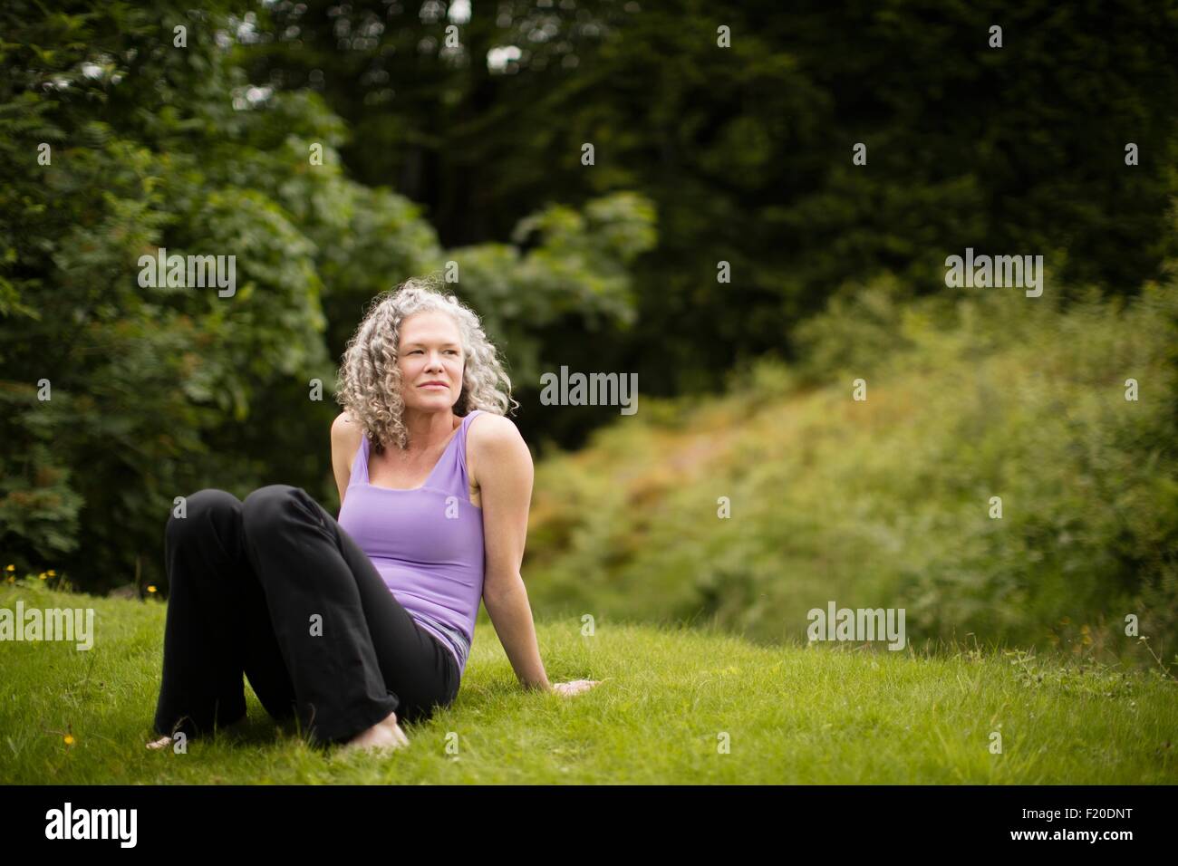 Reife Frau, die eine Pause von Yoga-Praxis im Bereich Stockfoto