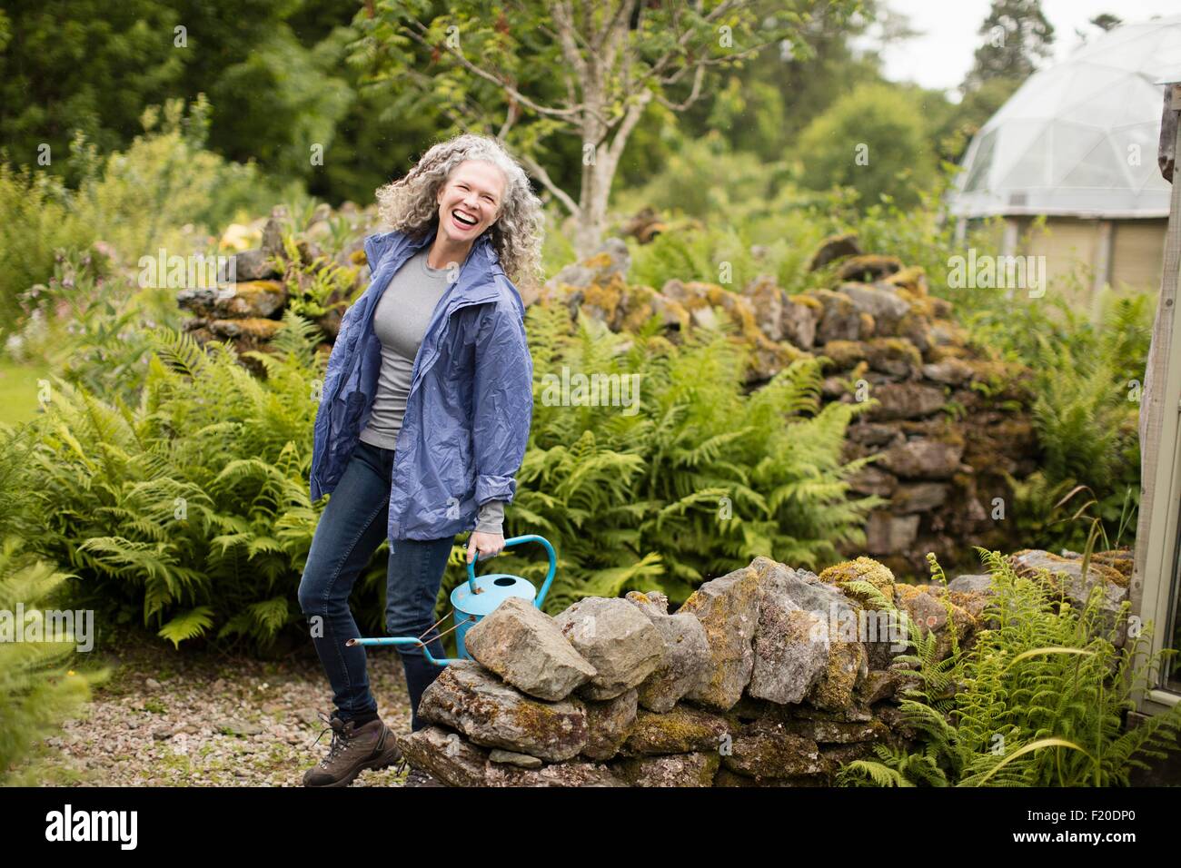 Porträt von Reife Frau mit Gießkanne im Garten Stockfoto