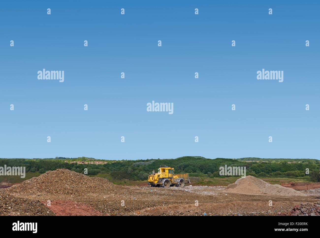 Bagger, die Abfälle auf Deponien vergraben Stockfoto