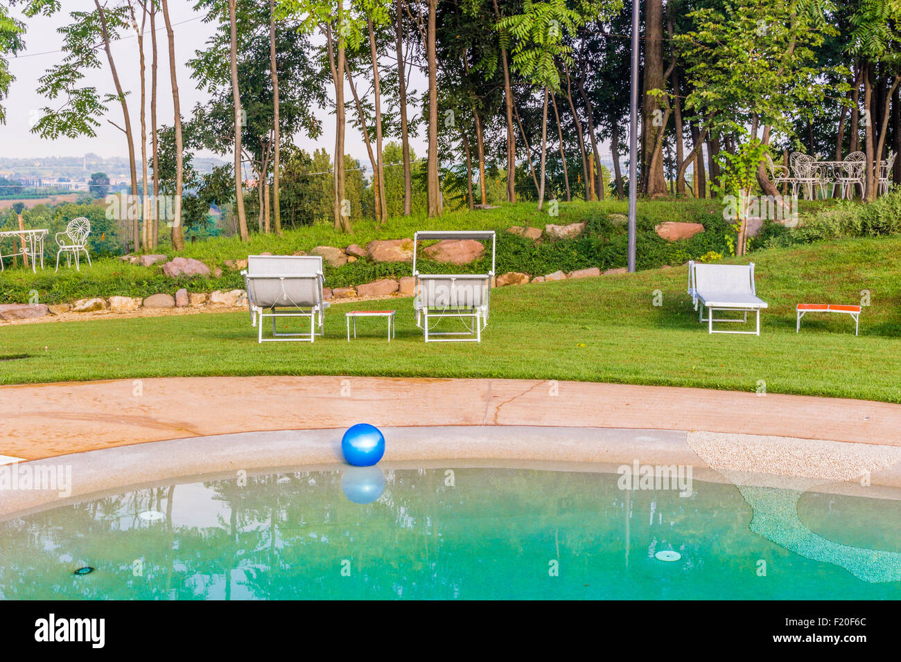 Traurigkeit und Spaß: einsame blaue Kugel schwimmt auf dem Wasser eines Schwimmbades Stockfoto