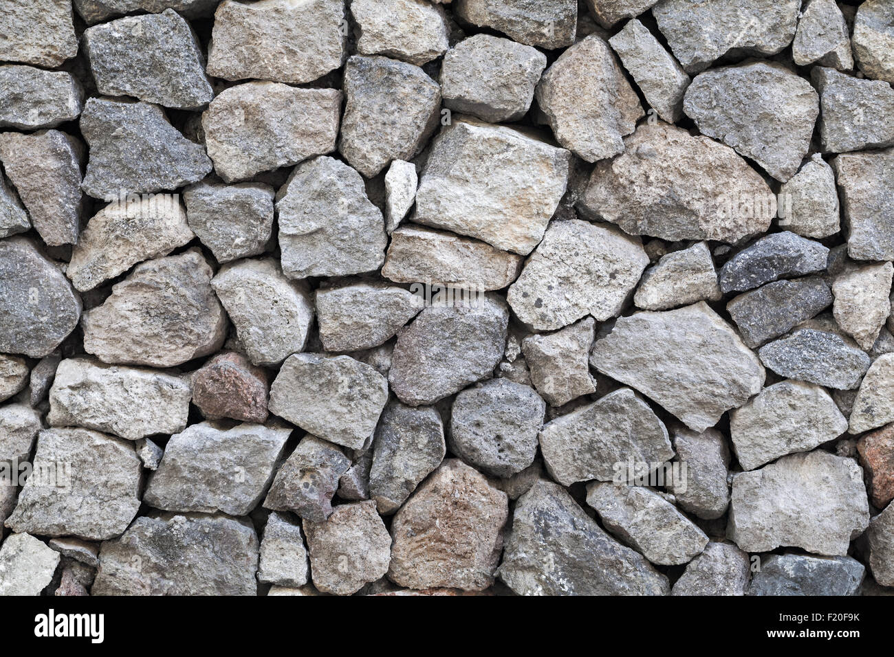 Hintergrundtextur Steinmauer grau grobem Granit Stockfoto