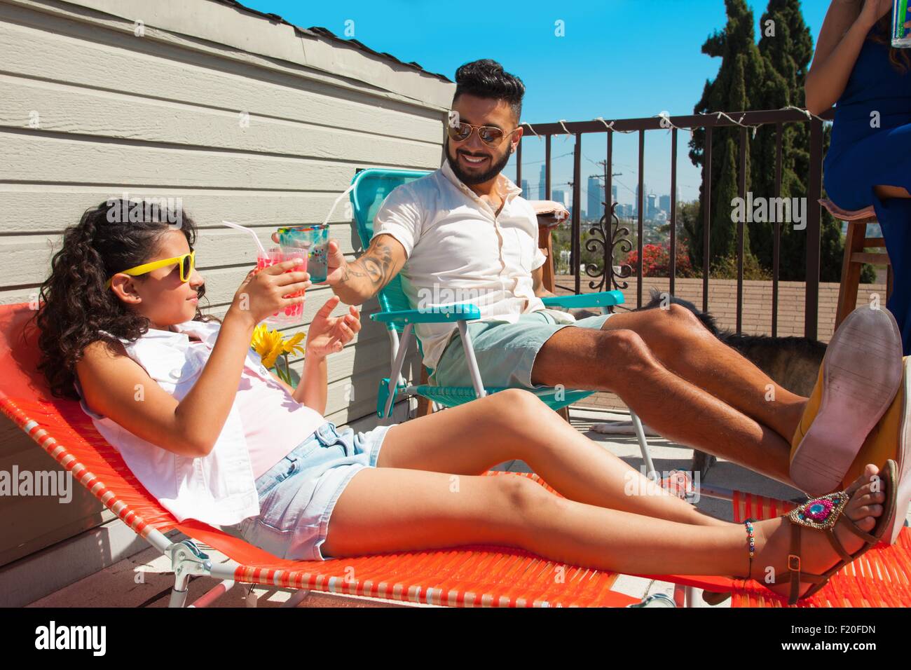 Mädchen und ihr Vater Toasten mit Saft Getränk auf der Terrasse Stockfoto