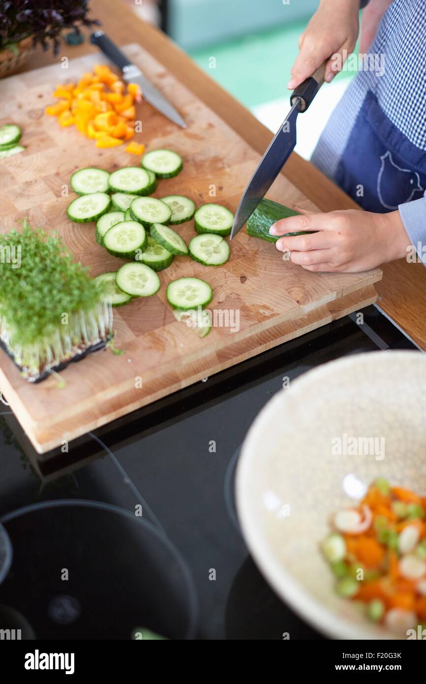 Frau, schneiden Gurke in Küche Stockfoto