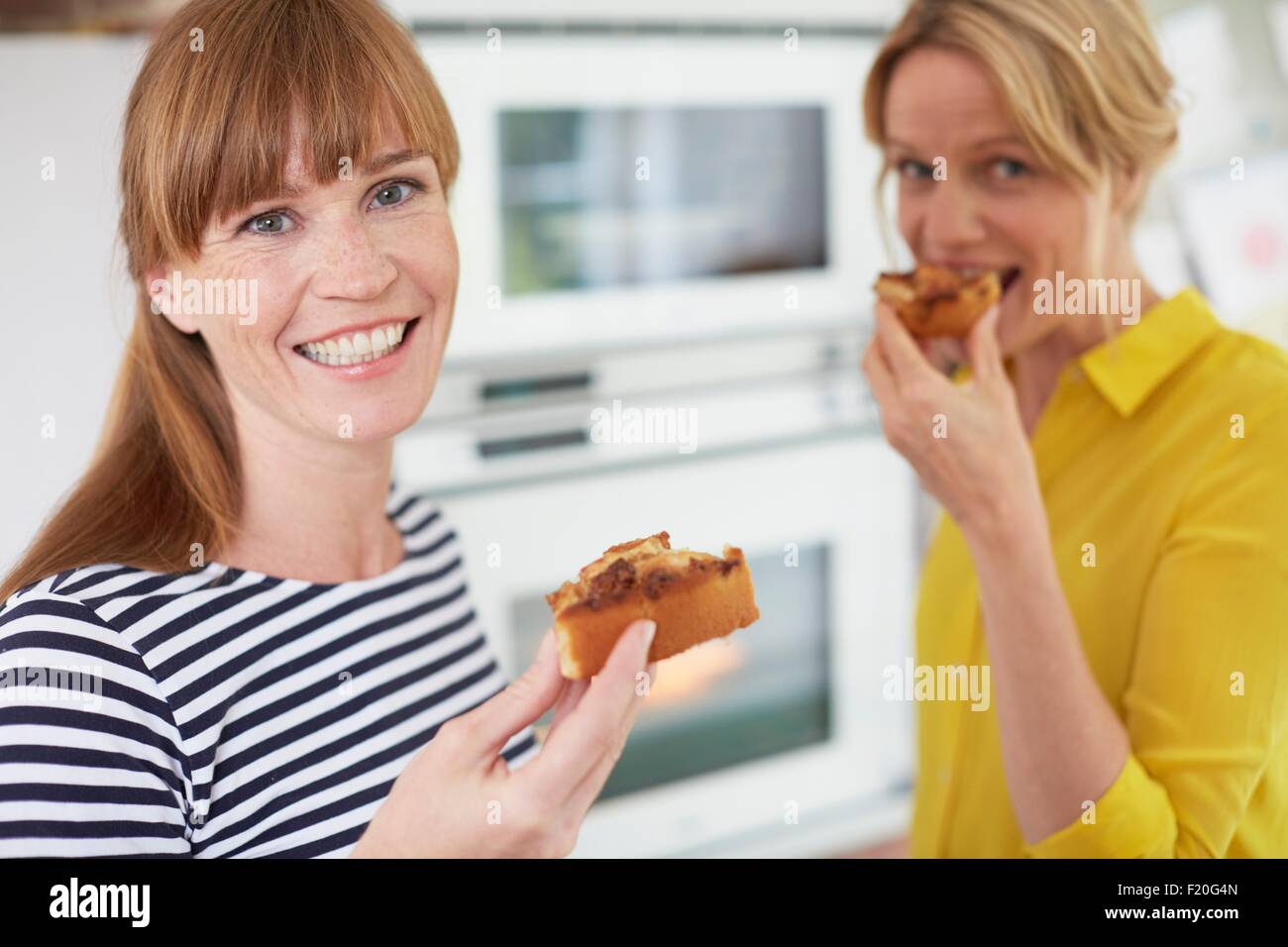 Frauen essen Kuchen in Küche Stockfoto