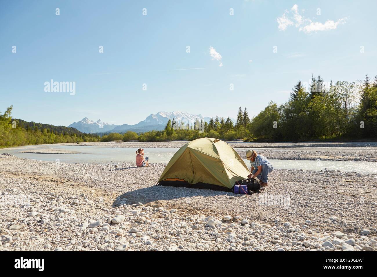 Paar Errichtung gelbe Zelt in der Nähe von Wasser, Wallgau, Bayern, Deutschland Stockfoto