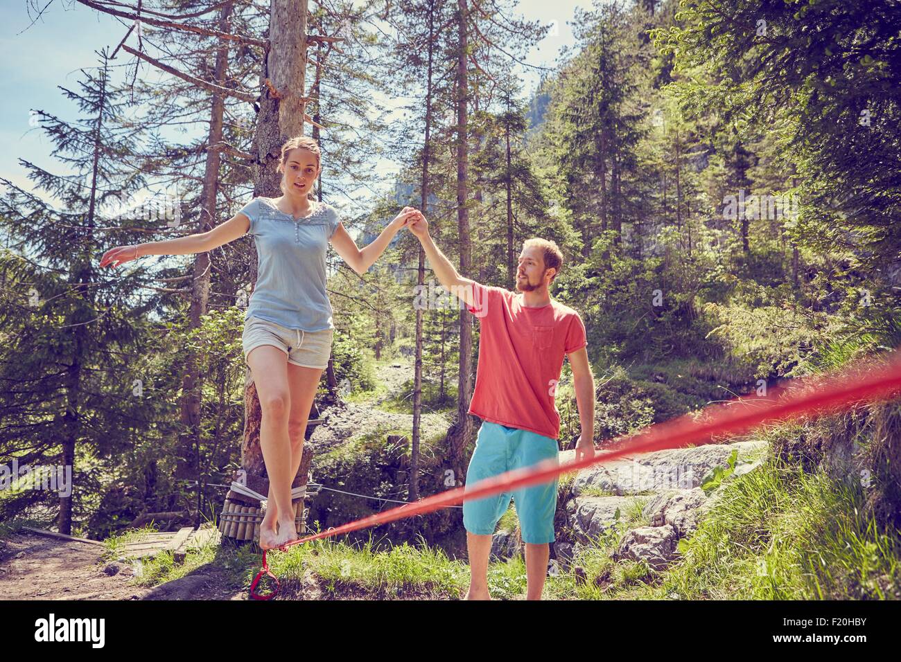 Frau balancieren auf Seil mit Hilfe von Mann, Ehrwald, Tirol, Österreich Stockfoto
