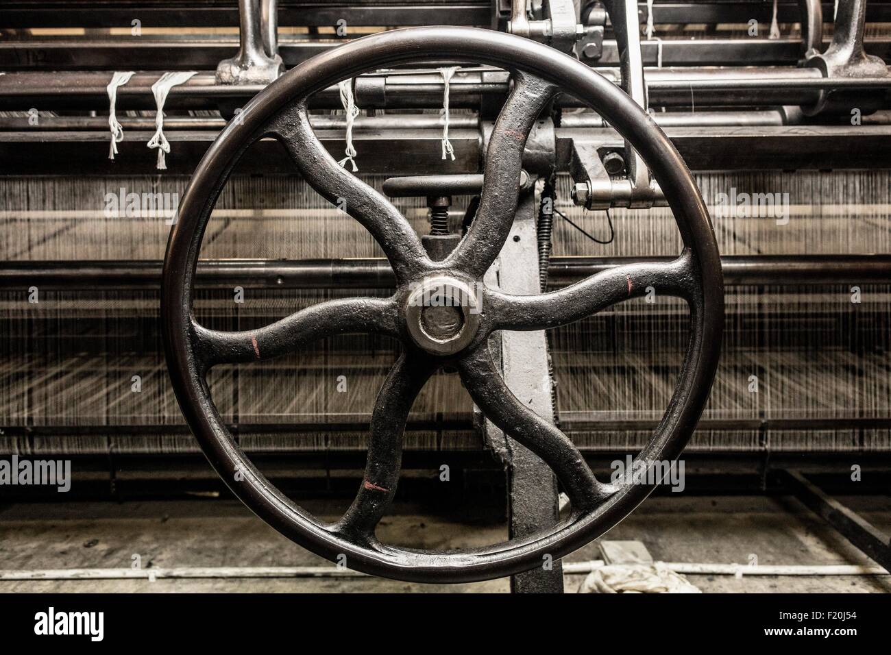 Eisenrad auf alten Webmaschine in Textilfabrik Stockfoto