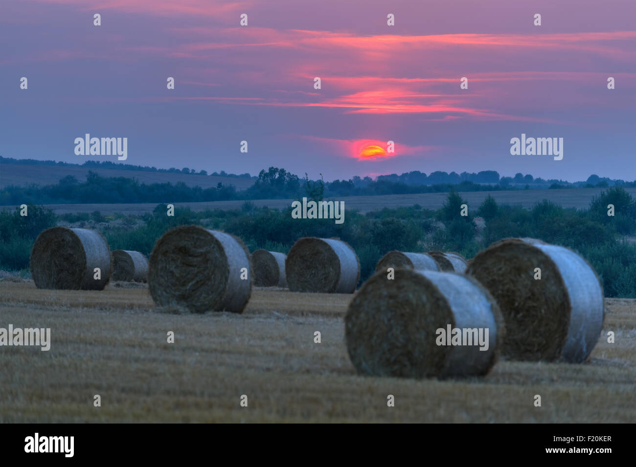 Erstaunliche Ländliches Motiv auf Herbst Feld mit Stroh Rollen und dramatische Abendlicht. Stockfoto
